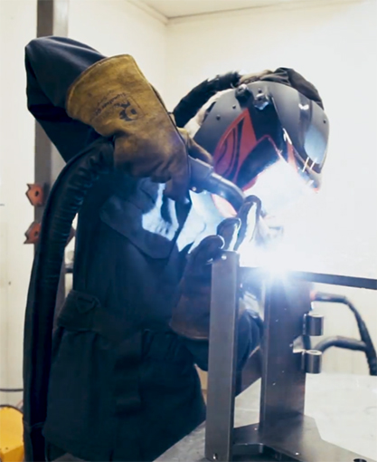 Man welding a press machine