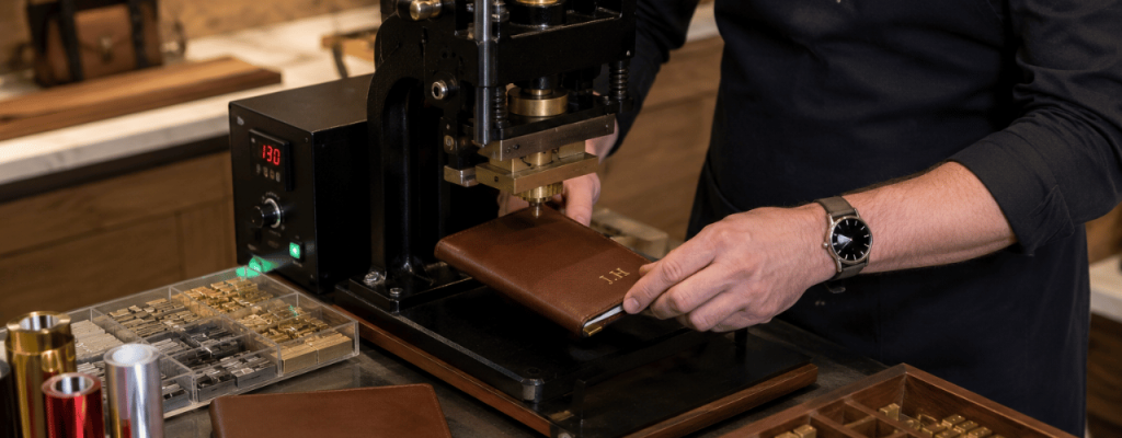 Retailer using a hot foil press to personalise a leather notebook at an in-store workstation