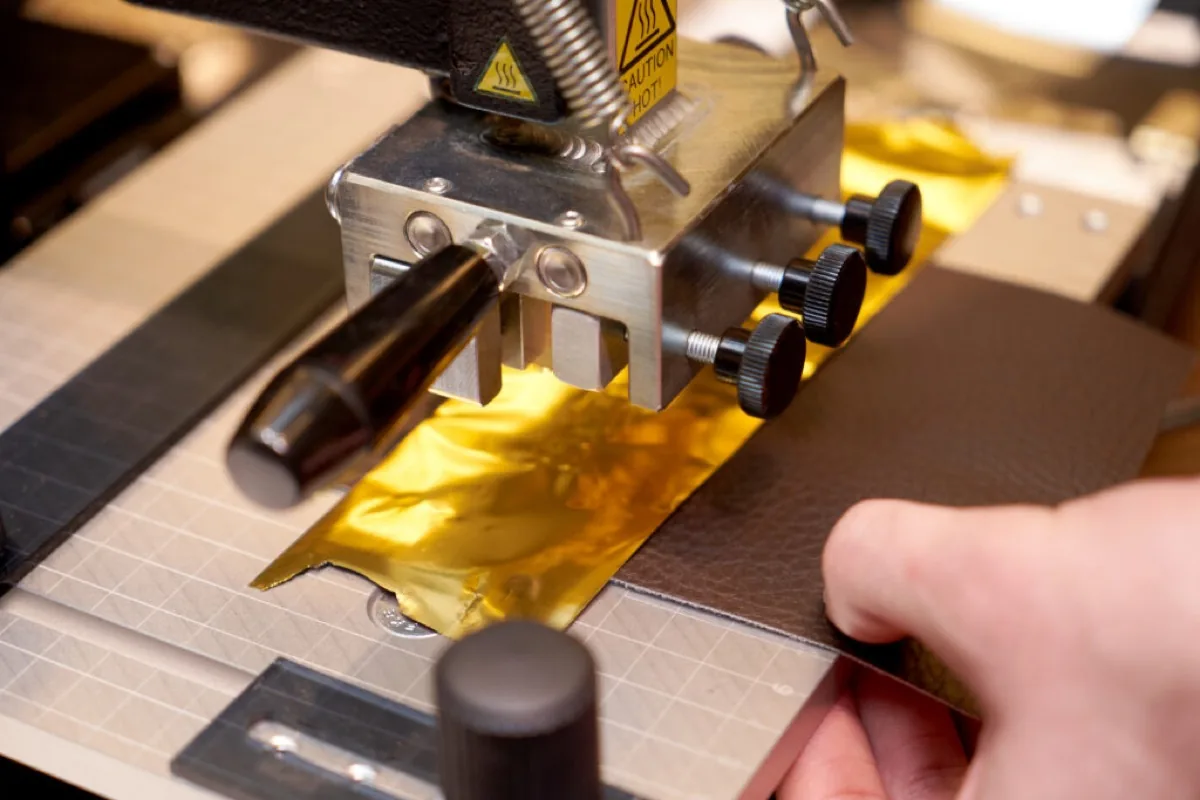 A leather craftsman using the KSF 1 hot foil press